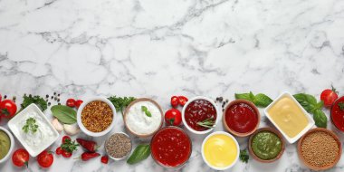Flat lay composition with different sauces and space for text on marble background clipart