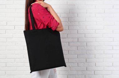 Brick Wall, closeup yakın şık boş Eko çanta ile kadın. Metin alanı