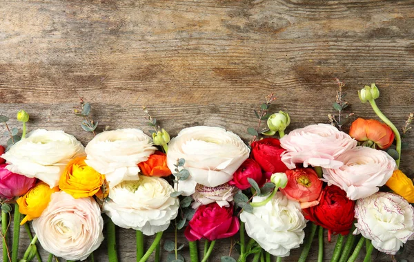 Mooie Ranunculus bloemen en ruimte voor tekst op houten achtergrond, vlakke lay — Stockfoto