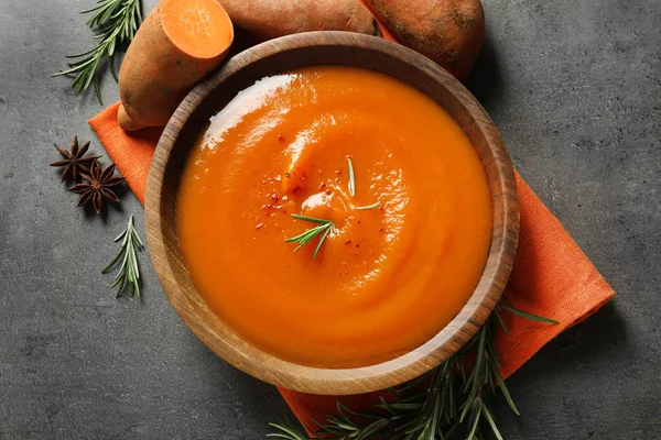 Flat lay composition with bowl of tasty sweet potato soup on grey background — Stock Photo, Image
