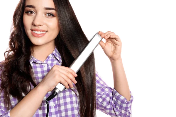 Mulher feliz usando ferro de cabelo no fundo branco — Fotografia de Stock