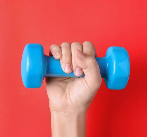 Woman holding vinyl dumbbell on color background, closeup — Stock Photo, Image