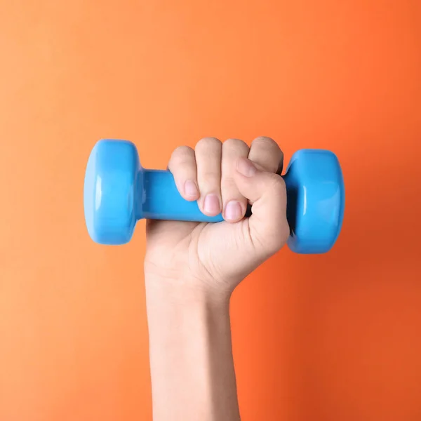 Woman holding vinyl dumbbell on color background, closeup — Stock Photo, Image