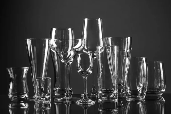 Leere Gläser für verschiedene Getränke auf dunklem Hintergrund — Stockfoto