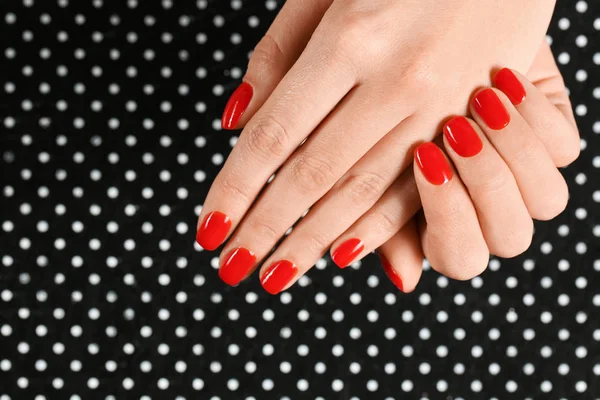 Woman showing manicured hands with red nail polish on patterned background, top view. Space for text — Stock Photo, Image