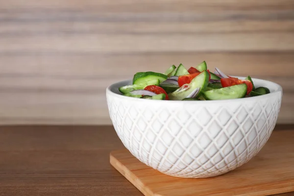 Schüssel mit leckerem Gurkentomatensalat auf Holztisch. Raum für Text — Stockfoto