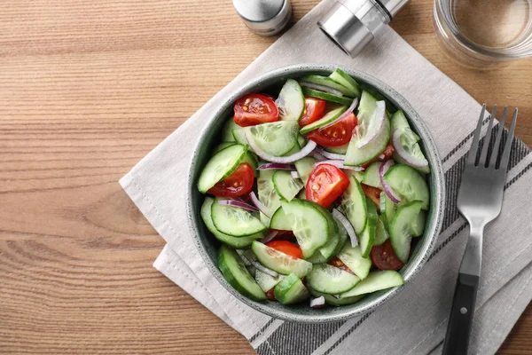 Schüssel mit leckerem Gurkentomatensalat auf Holztisch serviert, flach gelegt. Raum für Text — Stockfoto