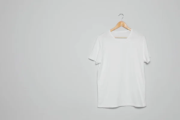 Hanger with blank t-shirt on gray background. Mock up for design — Stock Photo, Image