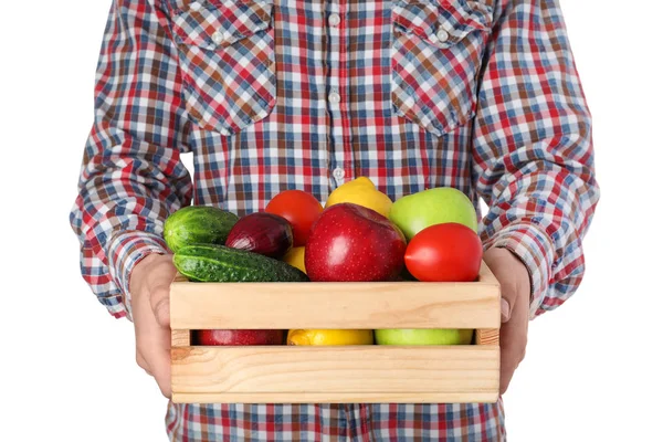 Muž držící dřevěnou bednu naplněnou čerstvou zeleninou a ovocem na bílém pozadí, v šatně — Stock fotografie