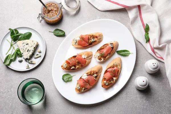 Composizione flat lay con gustose bruschette sulla tavola grigia — Foto Stock