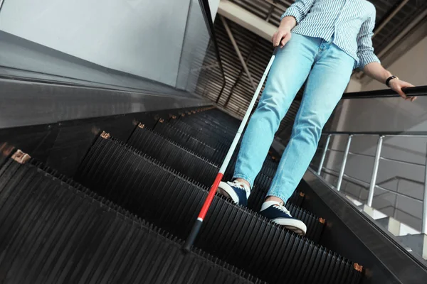 Slepá osoba s dlouhou hůlkou na eskalátoru uvnitř — Stock fotografie