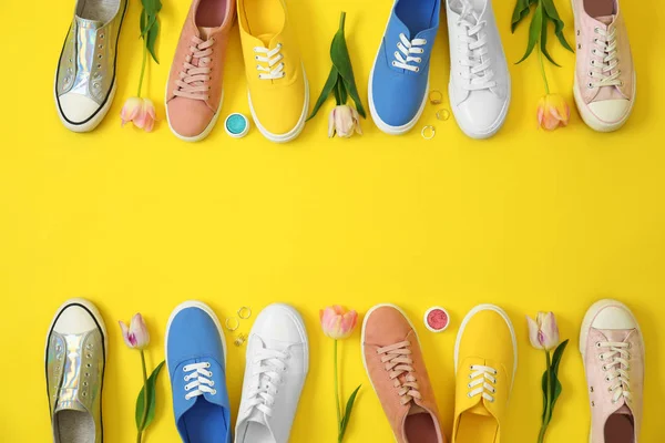 Плоская композиция с различными кроссовками и аксессуарами на цветном фоне, место для текста. Модный весенний вид — стоковое фото