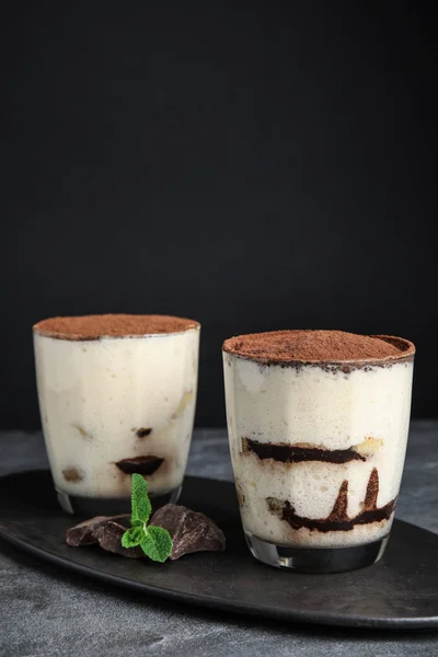 Två glas tiramisu kaka på bordet mot mörk bakgrund — Stockfoto