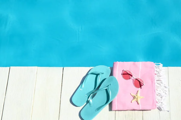 Strand-Accessoires auf Holzdeck in der Nähe des Schwimmbades. Raum für Text — Stockfoto