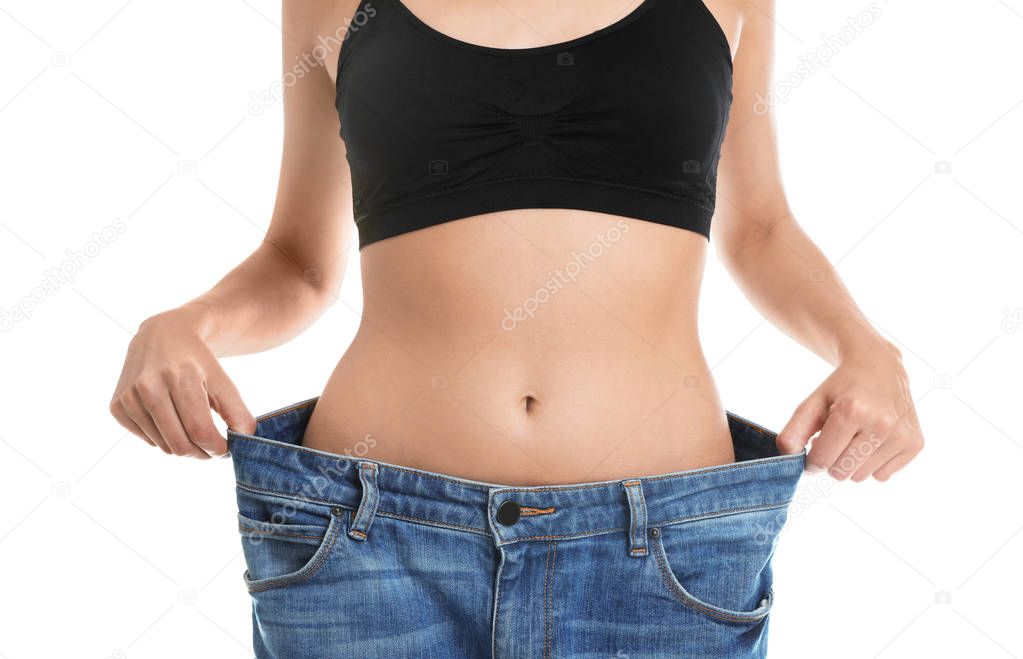 Young woman with slim body wearing her old big jeans on white background, closeup