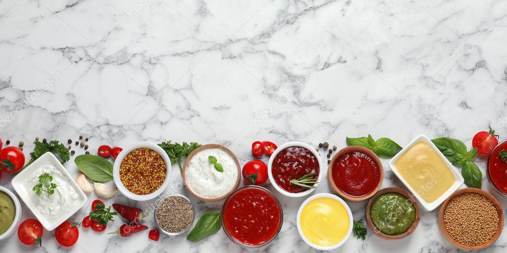 Flat lay composition with different sauces and space for text on marble background