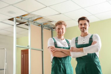 İçeride üniformalı inşaat işçileri. Ev onarım hizmeti