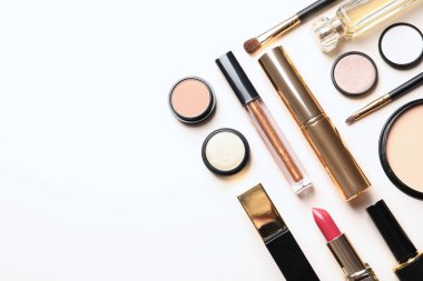 Beyaz arka planda farklı lüks makyaj ürünleri, üst görünüm