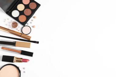 Beyaz arka planda farklı lüks makyaj ürünleri, üst görünüm