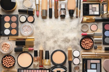 Çerçeve altın arka planda farklı lüks makyaj ürünleri yapılmış, düz yatıyordu. Metin alanı