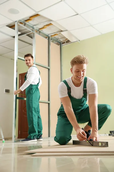 在室内安装干墙的青年工人。家庭维修服务 — 图库照片
