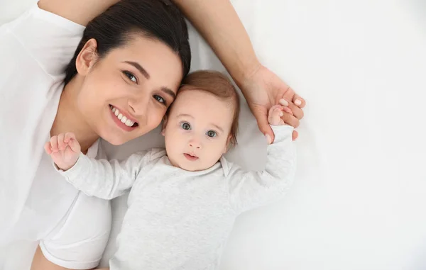 Ritratto di madre con il suo bambino carino sdraiato sul letto, vista dall'alto — Foto Stock