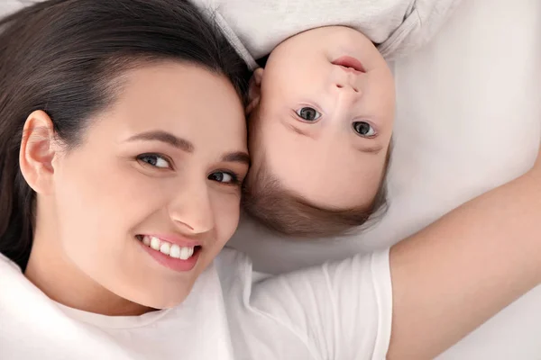 Portré anya vele aranyos baba feküdt az ágyban, felülnézet — Stock Fotó