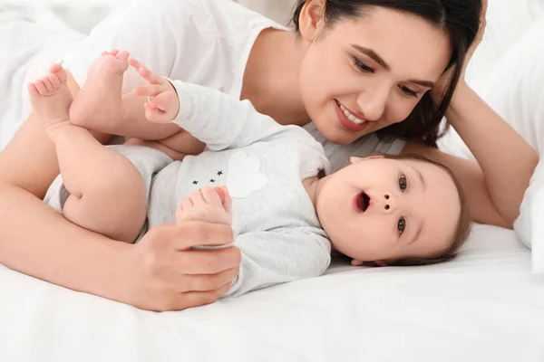 Cute baby and mother lying on bed — Stock Photo, Image