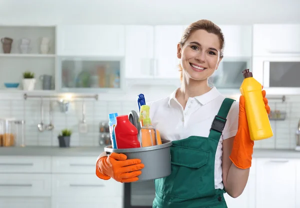 Portrait de jeune femme avec lavabo de détergents et bouteille dans la cuisine. Service de nettoyage — Photo