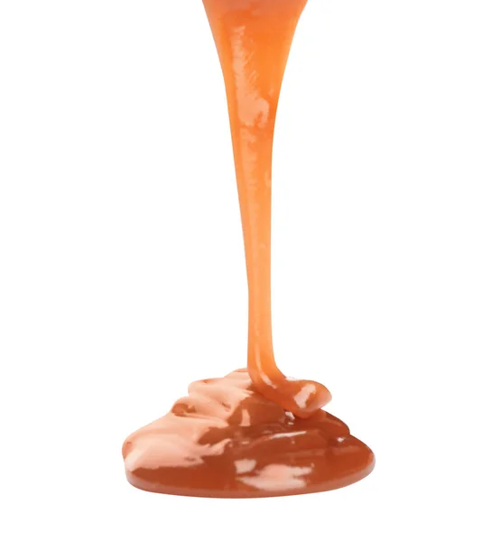 Gieten zoete karamel saus op witte achtergrond — Stockfoto