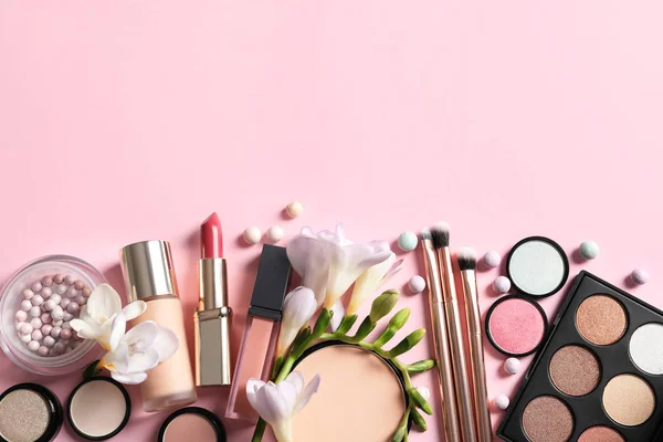 Olika Makeup-produkter med blommor på färg bakgrund. Utrymme för text — Stockfoto