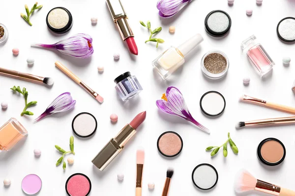 Diferentes productos de maquillaje y flores sobre fondo blanco, vista superior — Foto de Stock