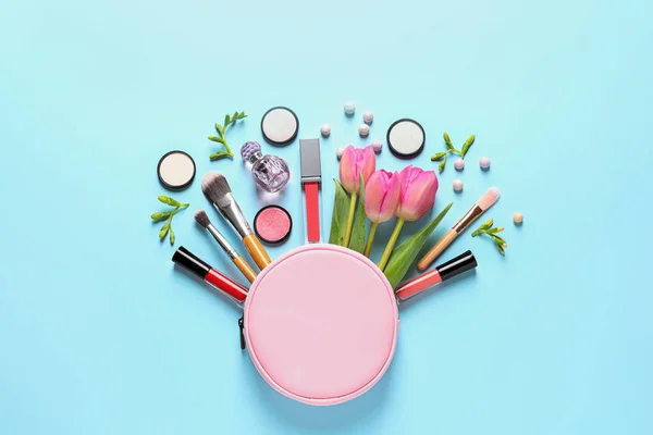 Макияж продукты, цветы и косметические сумки на цветном фоне, плоский укладки — стоковое фото