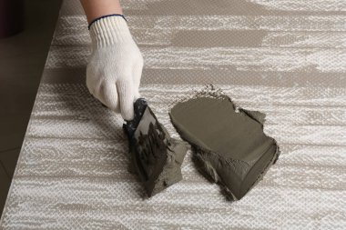 İşçi spatula, closeup ile seramik çini üzerinde beton yaymak. Metin alanı