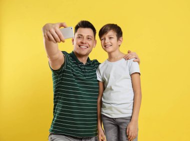 Baba ve oğlu renk arka plan üzerinde selfie alıyor