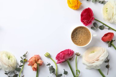 Beyaz arka planda bahar Ranunculus çiçekler ve fincan kahve ile düz yatıyordu kompozisyon. Metin alanı