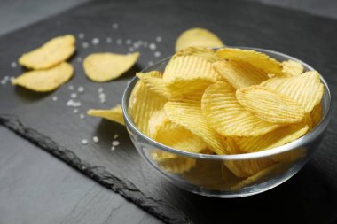 Gri masa üzerinde patates cips kase ile arduvaz kurulu, closeup. Metin alanı