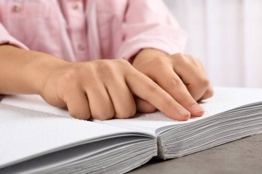 Braille ile yazılmış kitap okuyan kör kişi masada, closeup