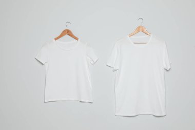 Gri arka planda boş t-shirt ile askılar. Tasarım için mock