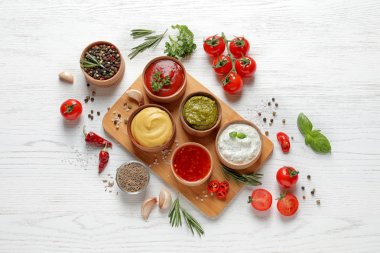 Beyaz ahşap arka planda farklı soslar ve malzemelerle düz yatıyordu kompozisyon