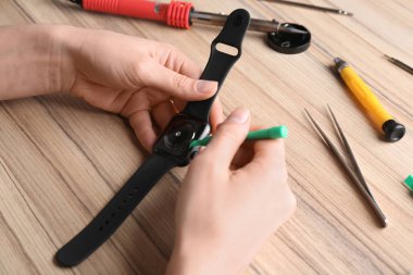 Teknisyen masada kırık akıllı saat sabitleme, çekim. Onarım hizmeti