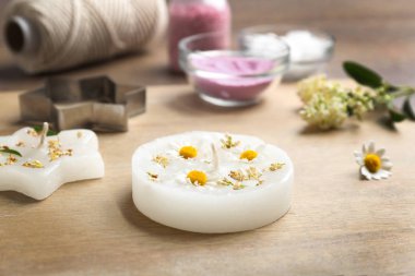 Ahşap arka planda farklı el yapımı mumlar ve kesici