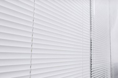 Arka plan olarak kapalı beyaz yatay jaluzi ile pencere