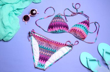 Renkli arka planda şık parlak bikini ve plaj aksesuarları, yukarıdaki görünüm