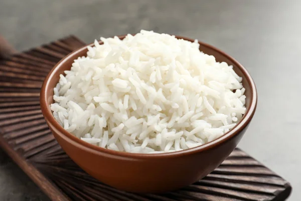 Tigela de saboroso arroz branco cozido na mesa cinza — Fotografia de Stock