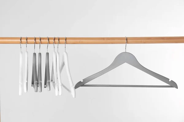 Wooden rack with clothes hangers on white background — Stock Photo, Image