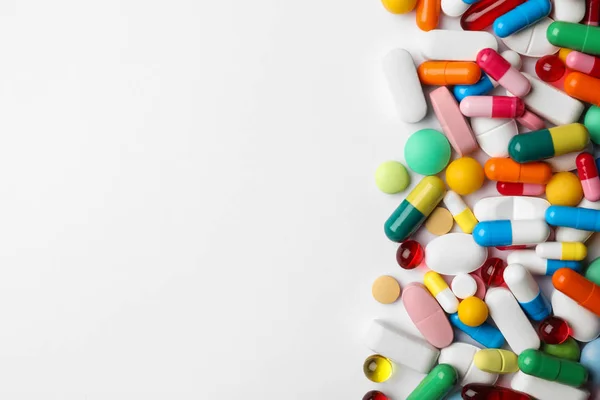 Diferentes pílulas no fundo branco, vista superior — Fotografia de Stock