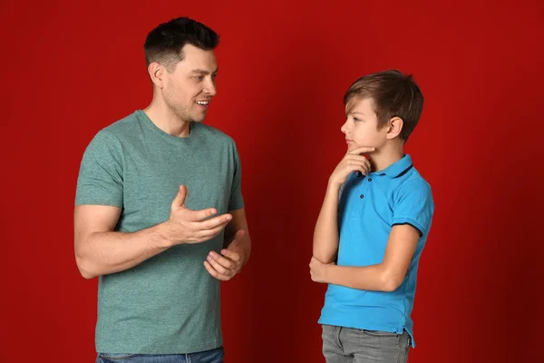 Тато говорить зі своїм сином на кольоровому фоні — стокове фото