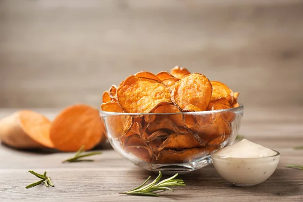 Deliciosas papas fritas dulces en tazón, romero y salsa en la mesa —  Fotos de Stock