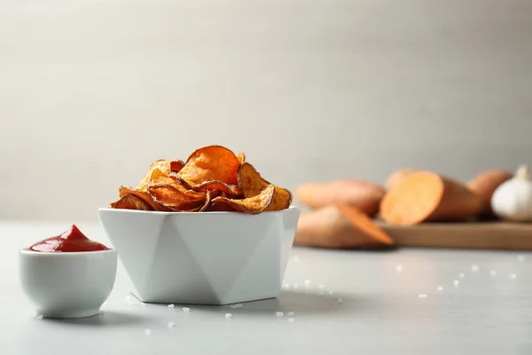 Deliciosas papas fritas dulces en tazón y salsa en la mesa. Espacio para texto —  Fotos de Stock